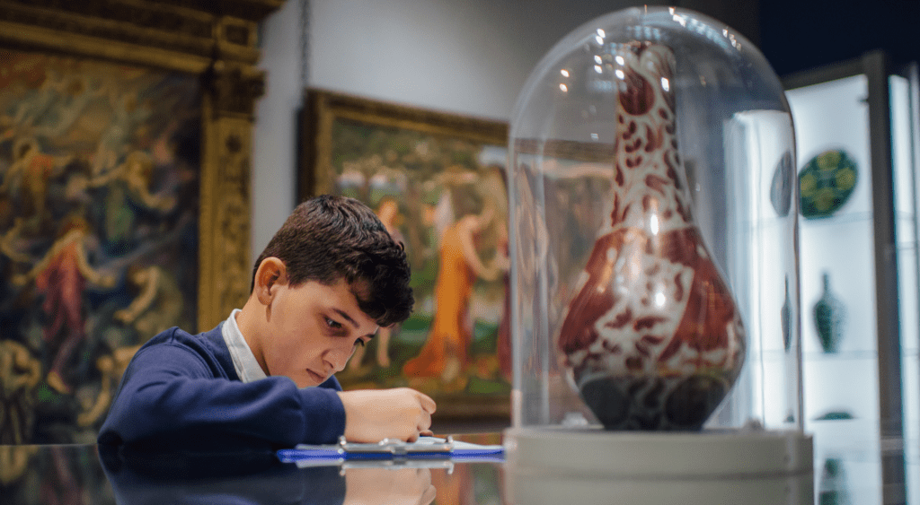 Boy studying a De Morgan vase